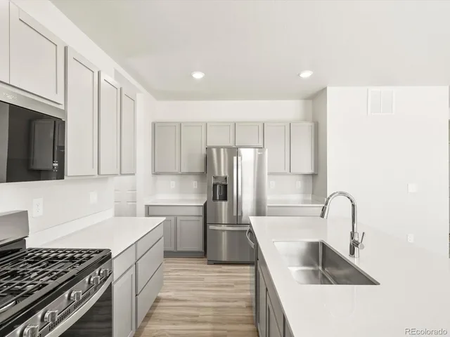 a kitchen with kitchen island a sink stove and refrigerator