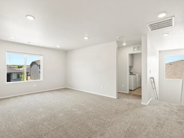 an empty room with a cabinet and mirrors