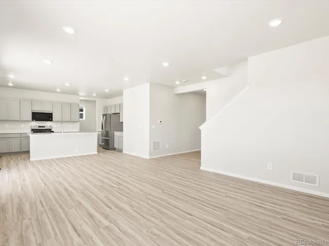 a view of a kitchen with wooden floor and windows