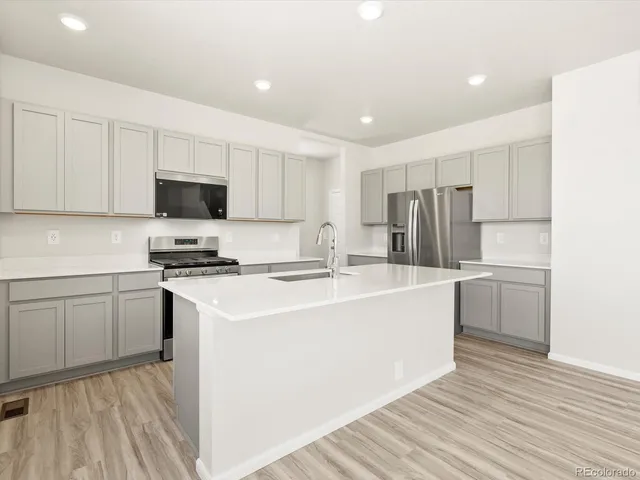 a kitchen with stainless steel appliances a refrigerator stove microwave and sink