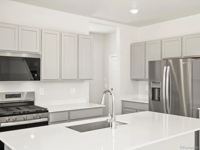a kitchen with stainless steel appliances a refrigerator and a stove top oven