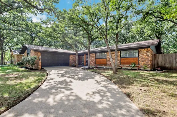 a view of a house with a yard and large tree