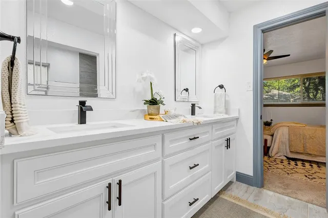 a kitchen with stainless steel appliances granite countertop a refrigerator a sink dishwasher and white cabinets with wooden floor