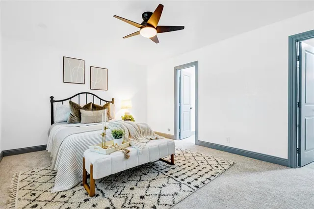 a bedroom with a bed and a chandelier fan