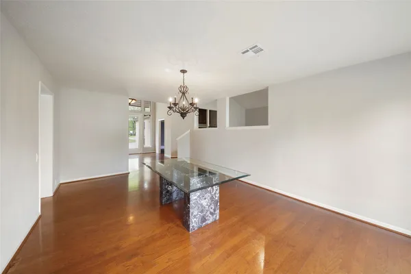 a room with wooden floor and chandelier