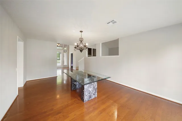 a room with wooden floor and chandelier