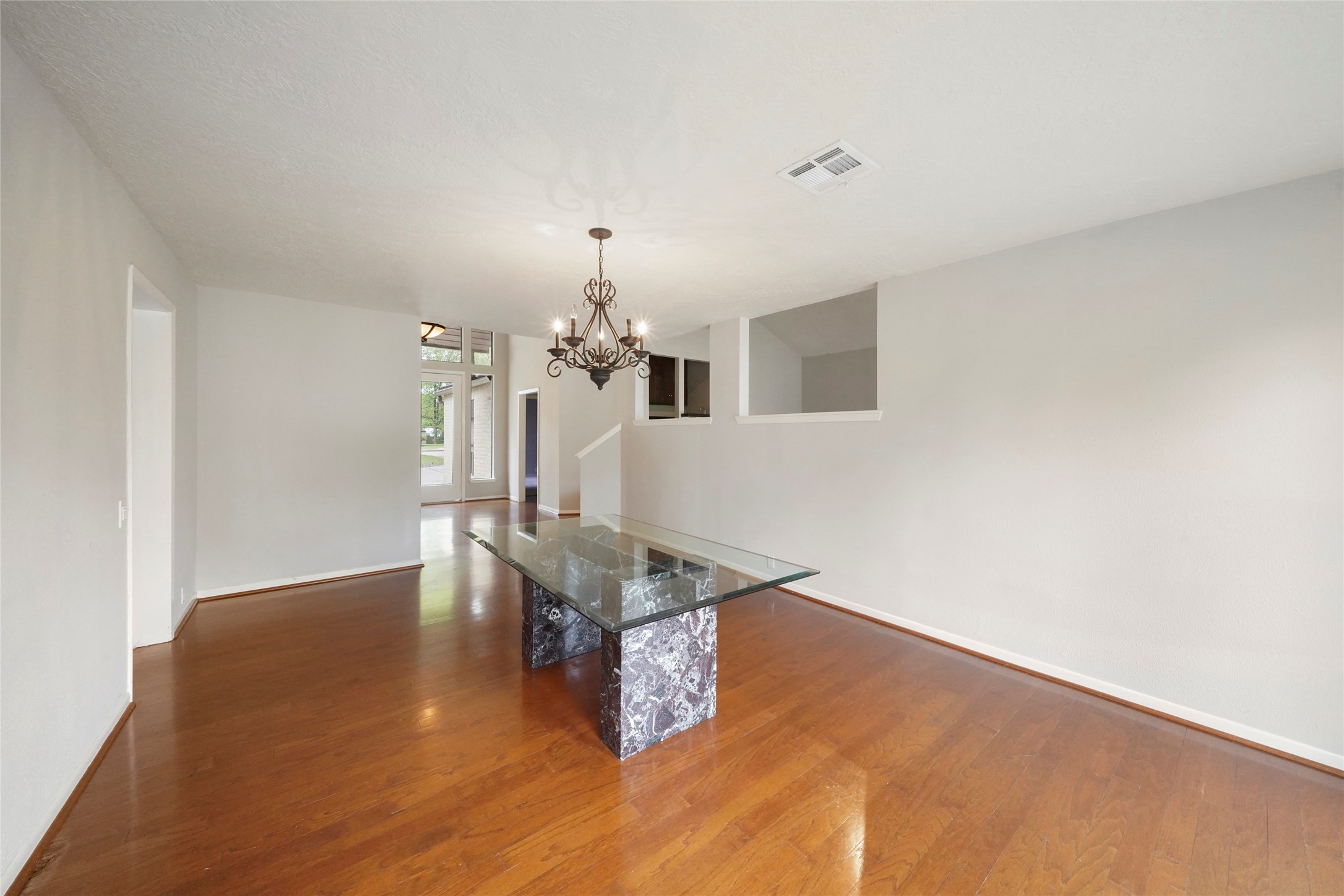 84 April Wind Drive South Conroe, TX 77356 - Photo 13 of 36 a room with wooden floor and chandelier