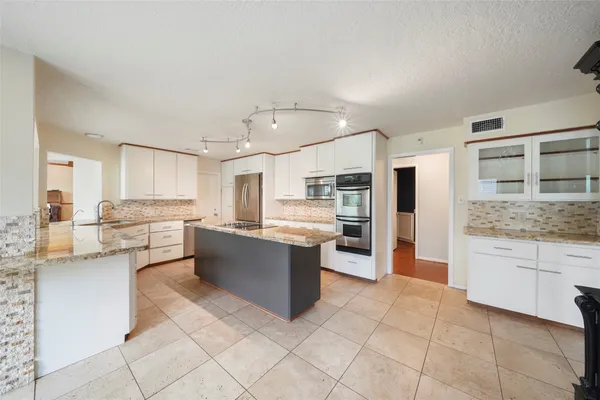 a large kitchen with cabinets and stainless steel appliances