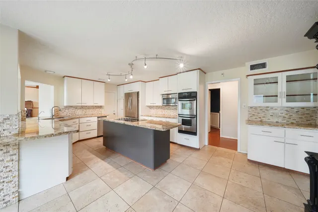 a large kitchen with cabinets and stainless steel appliances