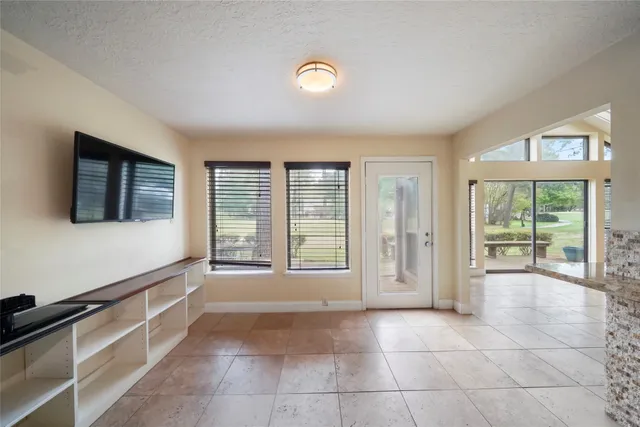 a view of an empty room with window and cabinet