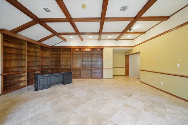 a view of an empty room with wooden ceiling