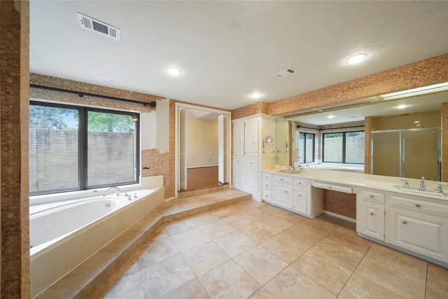 a large spacious bathroom with a large tub and shower