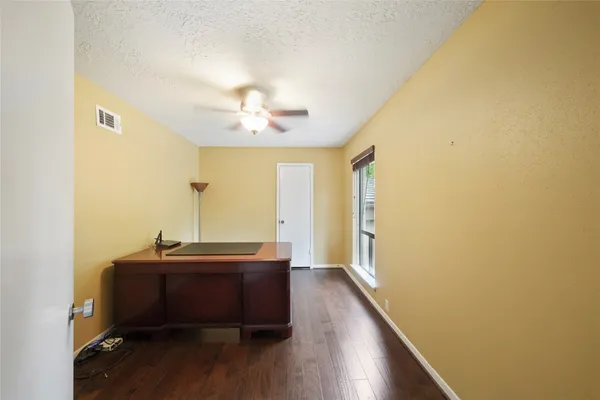 a view of room with a large window and wooden floor