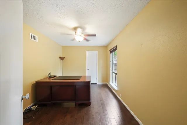a view of room with a large window and wooden floor