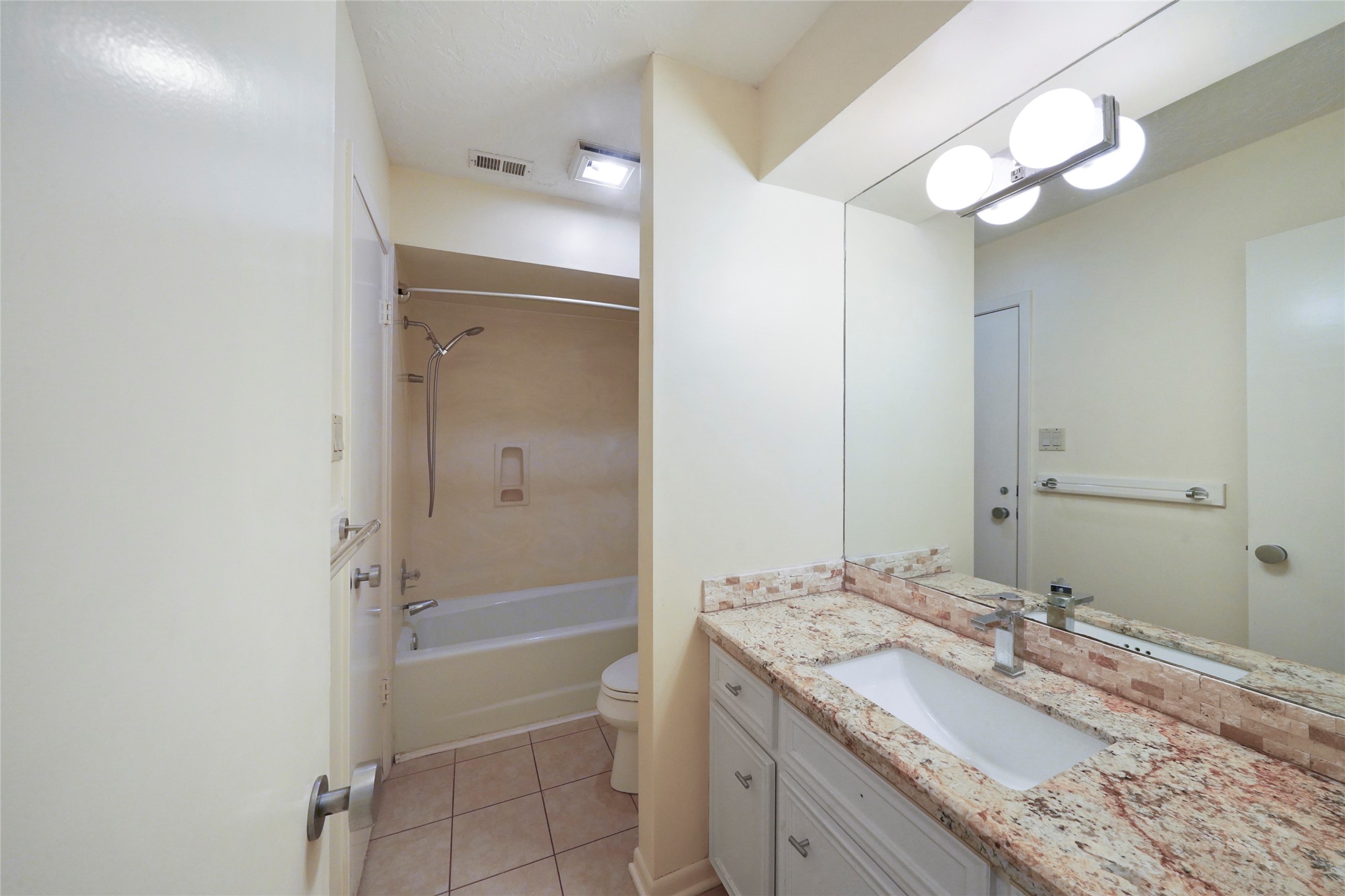 84 April Wind Drive South Conroe, TX 77356 - Photo 31 of 36 a bathroom with a granite countertop sink a mirror and a bathtub