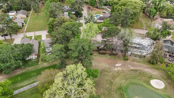 an aerial view of residential house with outdoor space and trees all around