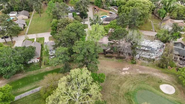 an aerial view of residential house with outdoor space and trees all around