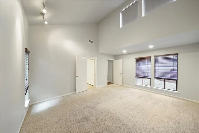 an empty room with windows and closet