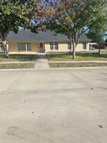 a front view of a house with a yard and trees