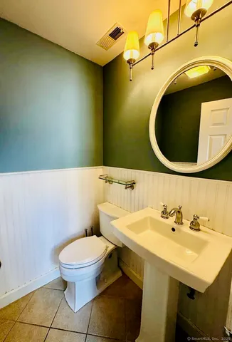 a bathroom with a sink a toilet and mirror