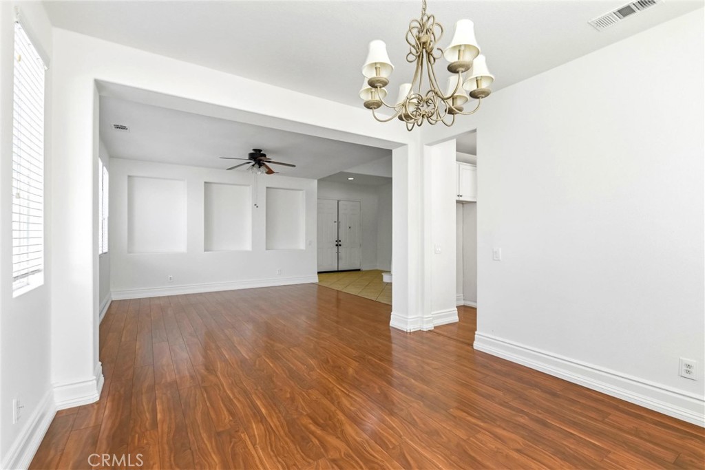 28799 First Star Court Menifee, CA 92584 - Photo 12 of 70 a view of an empty room with wooden floor and a chandelier