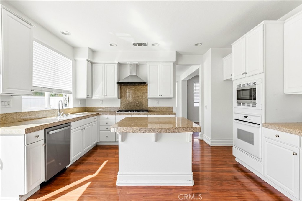 28799 First Star Court Menifee, CA 92584 - Photo 20 of 70 a large kitchen with stainless steel appliances granite countertop a stove a sink and white cabinets