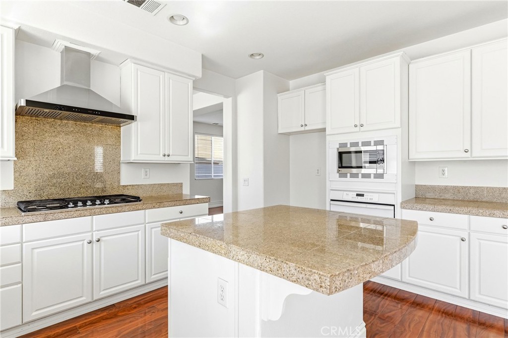 28799 First Star Court Menifee, CA 92584 - Photo 22 of 70 a kitchen with granite countertop a sink a stove and cabinets