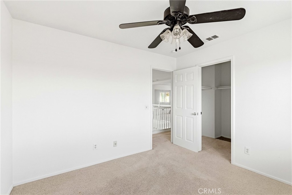 28799 First Star Court Menifee, CA 92584 - Photo 48 of 70 an empty room with a ceiling fan and carpet