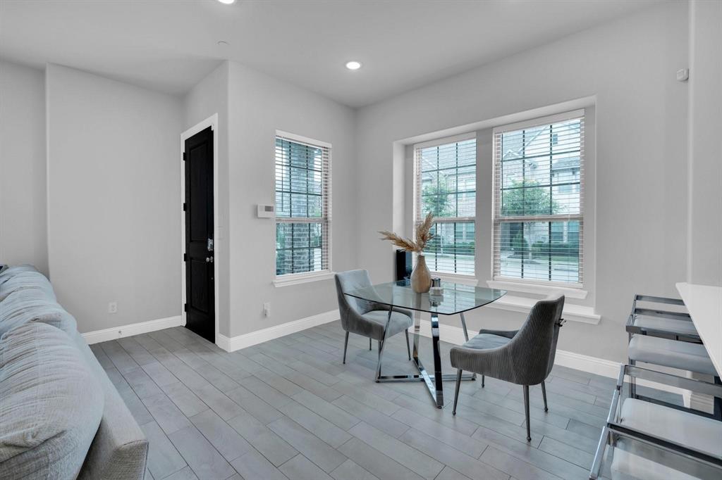 1498 Weston Road Dallas, TX 75234 - Photo 6 of 24 Living space featuring plank-style wood-finish flooring, two large windows with blinds, recessed lighting, and a dark paneled door with white trim
