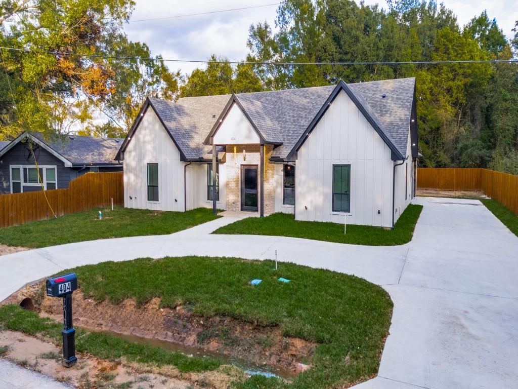a view of a house with a yard and large tree