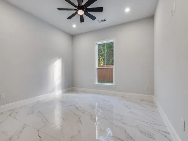 an empty room with a window and a fan