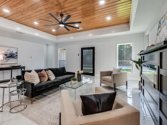 a living room with furniture a ceiling fan and a window