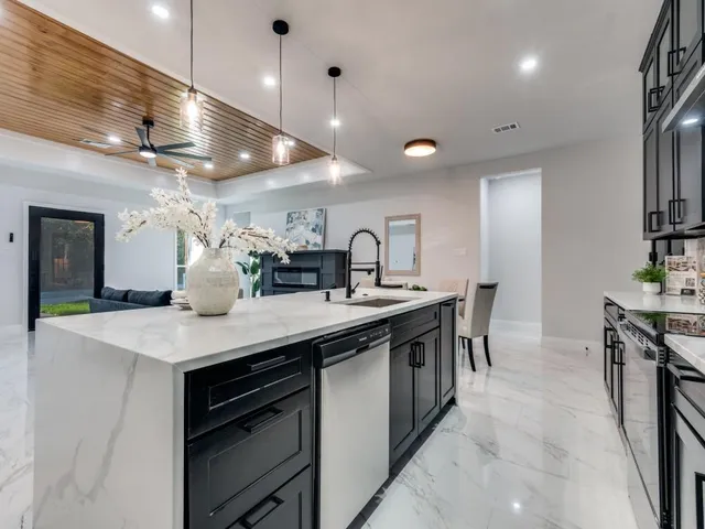a kitchen with stainless steel appliances granite countertop a sink a stove and a wooden floors