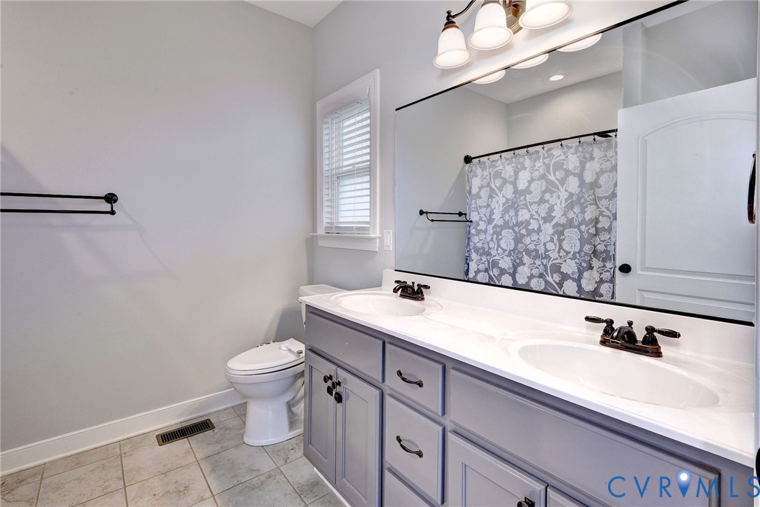 8904 Rock Cedar Road New Kent, VA 23124 - Photo 17 of 37 a bathroom with a sink a toilet and mirror