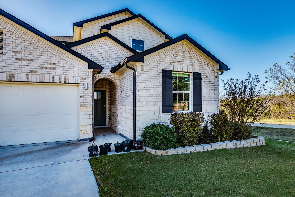 10932 Defender Trail Austin, TX 78754 - Photo 4 of 35 a front view of a house with a yard and garage