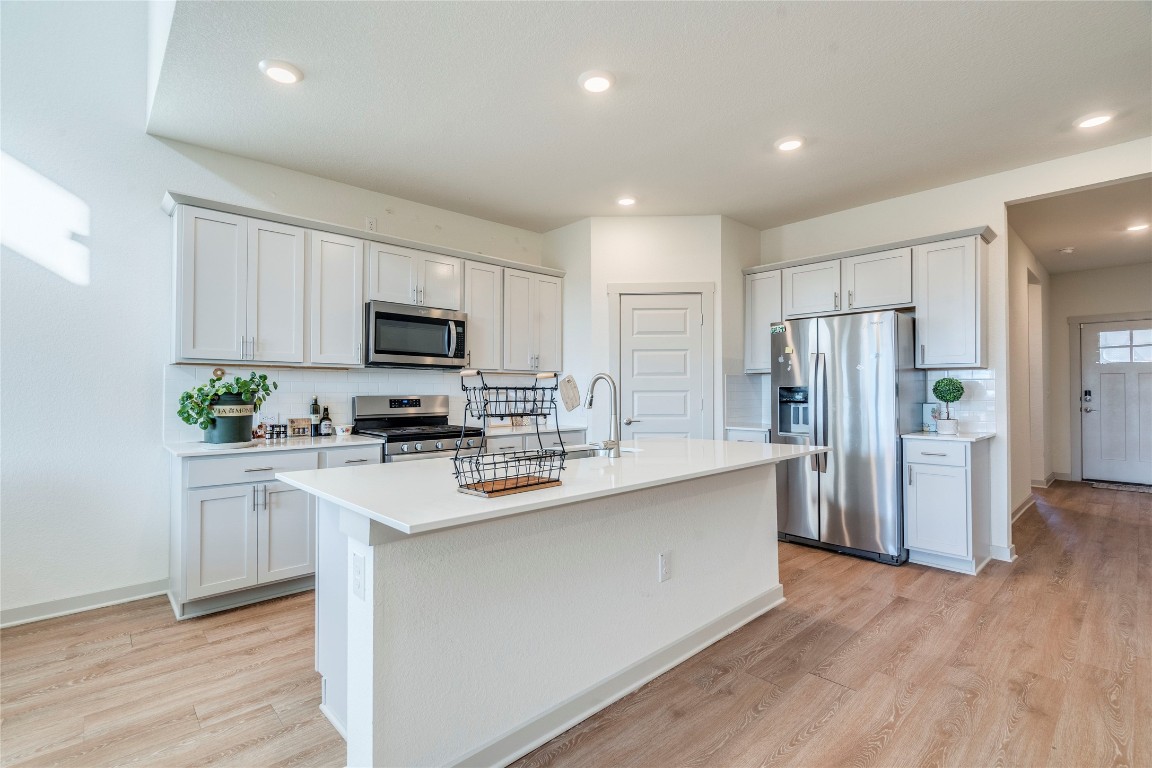 10932 Defender Trail Austin, TX 78754 - Photo 6 of 35 a kitchen with white cabinets and stainless steel appliances