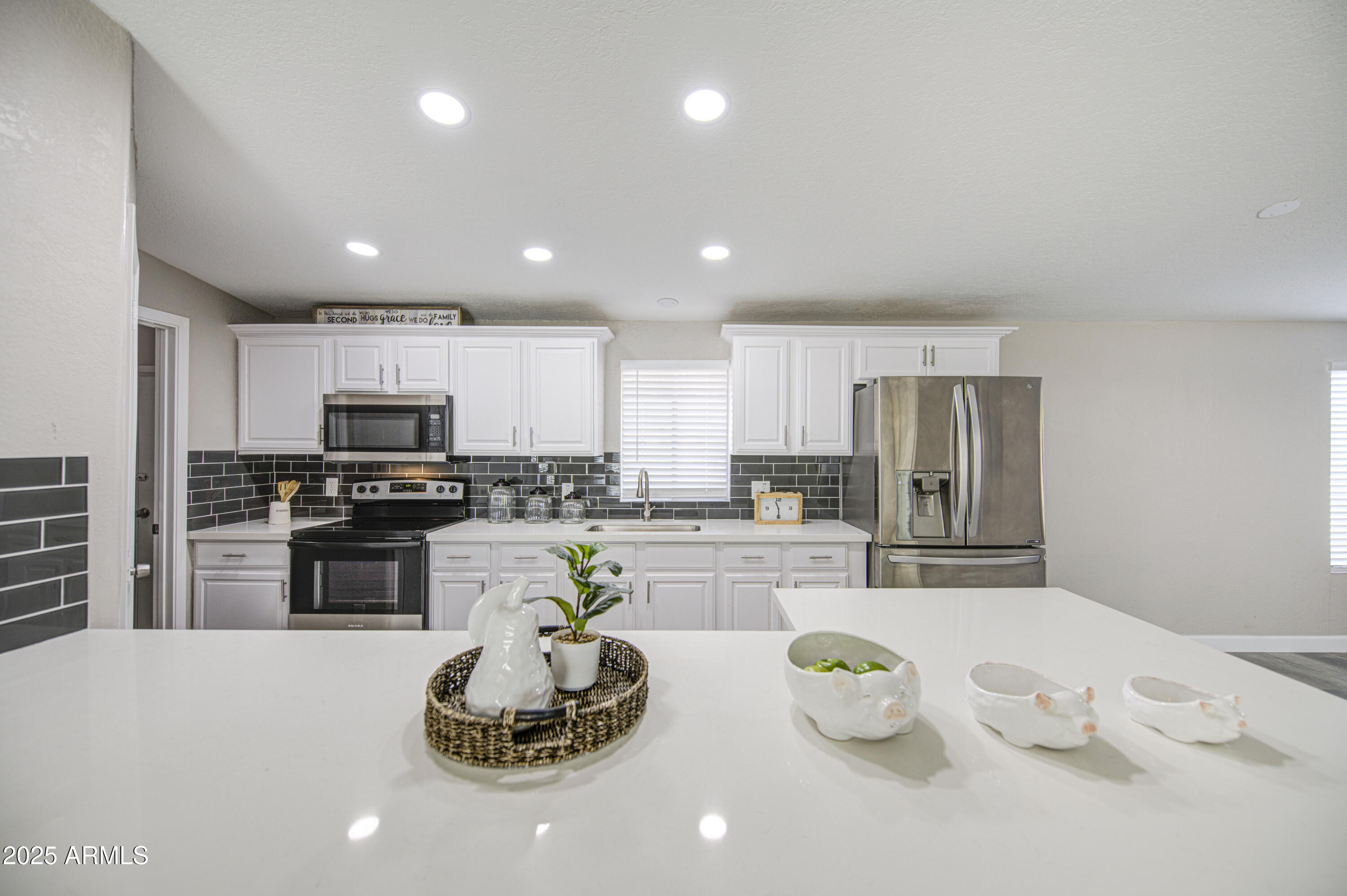 19954 West Teepee Road Buckeye, AZ 85326 - Photo 12 of 46 a kitchen with stainless steel appliances kitchen island granite countertop a sink and refrigerator