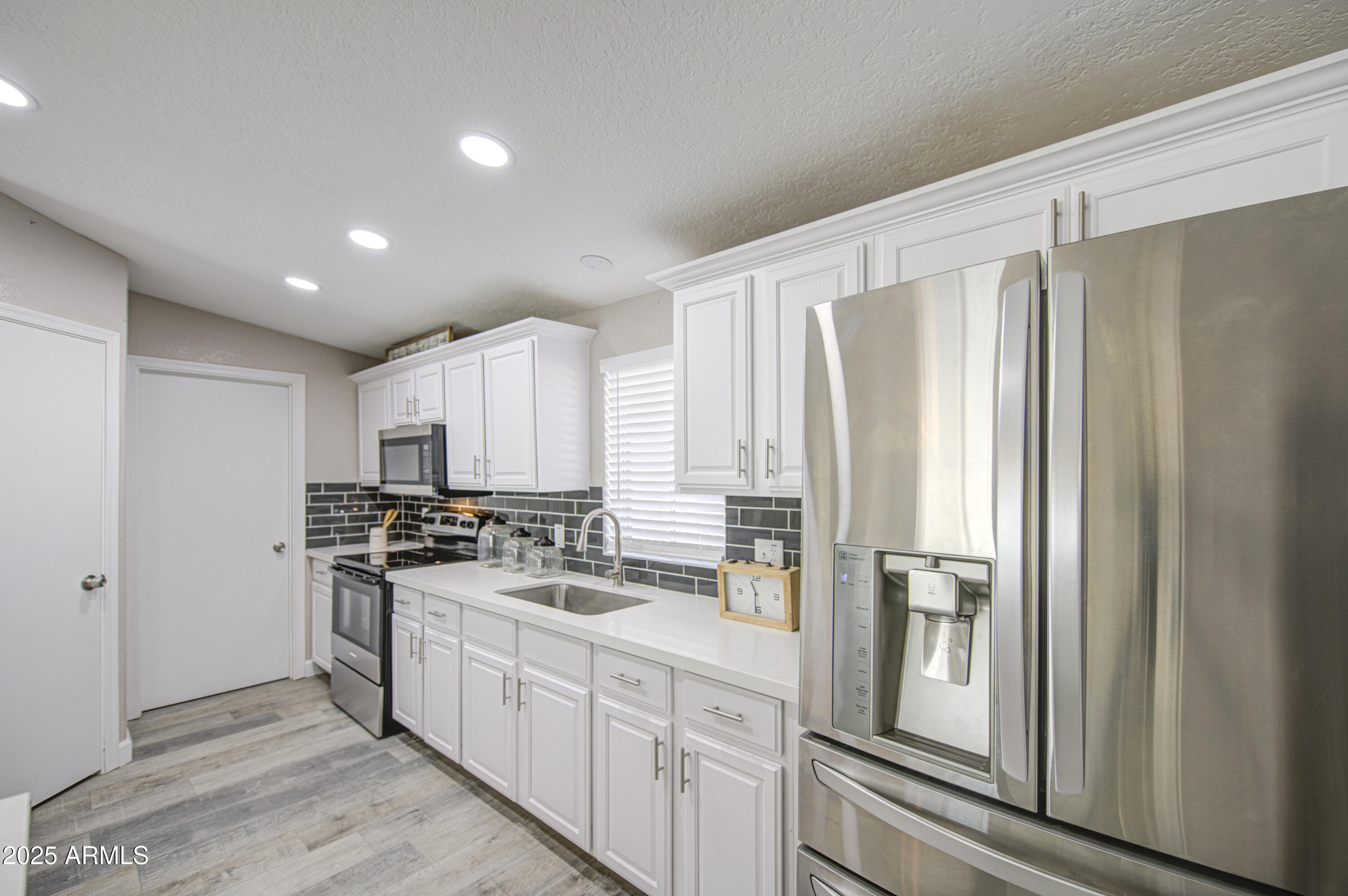 19954 West Teepee Road Buckeye, AZ 85326 - Photo 16 of 46 a kitchen with stainless steel appliances a refrigerator sink and cabinets