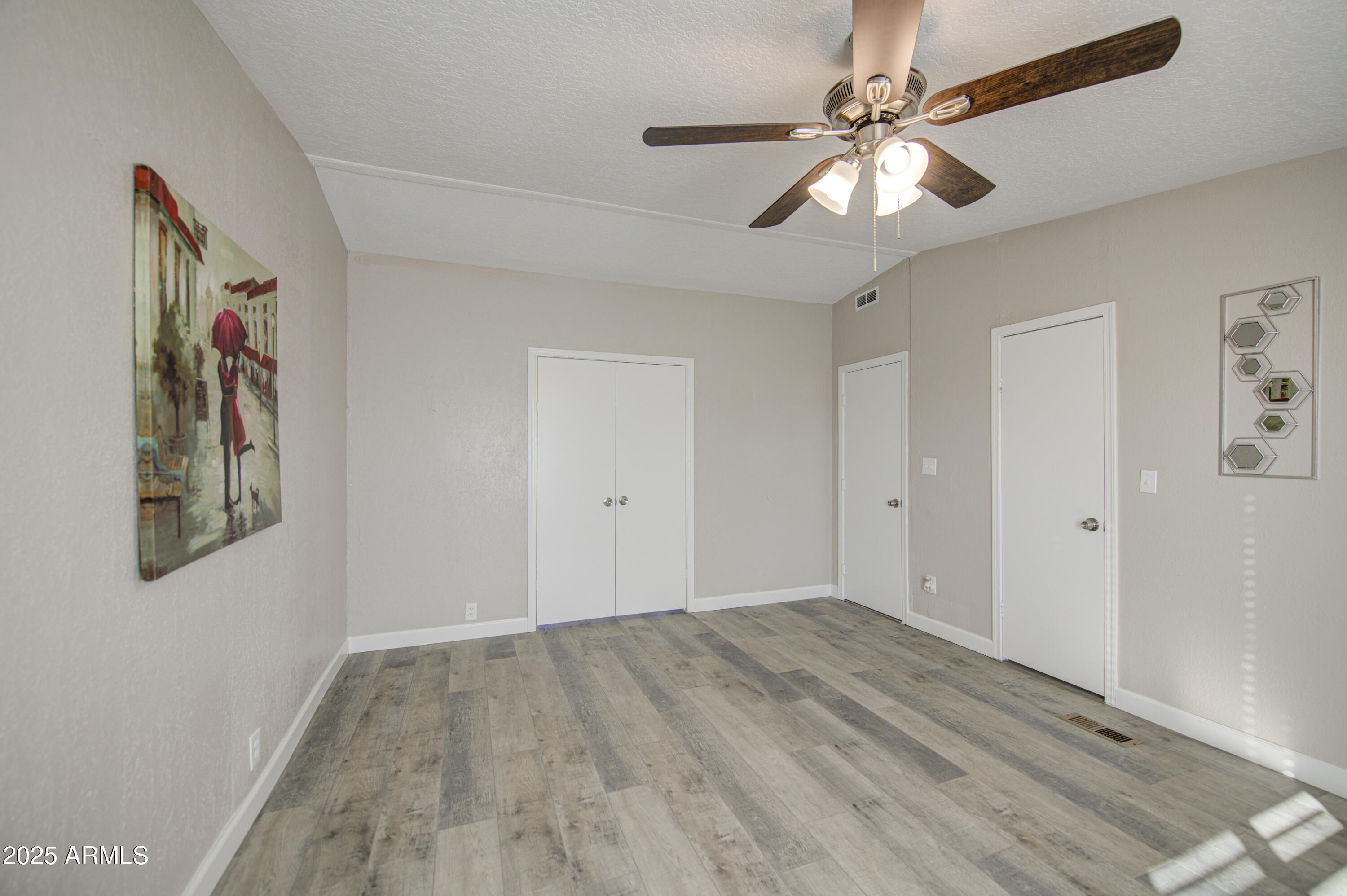19954 West Teepee Road Buckeye, AZ 85326 - Photo 27 of 46 wooden floor in an empty room with a chandelier fan