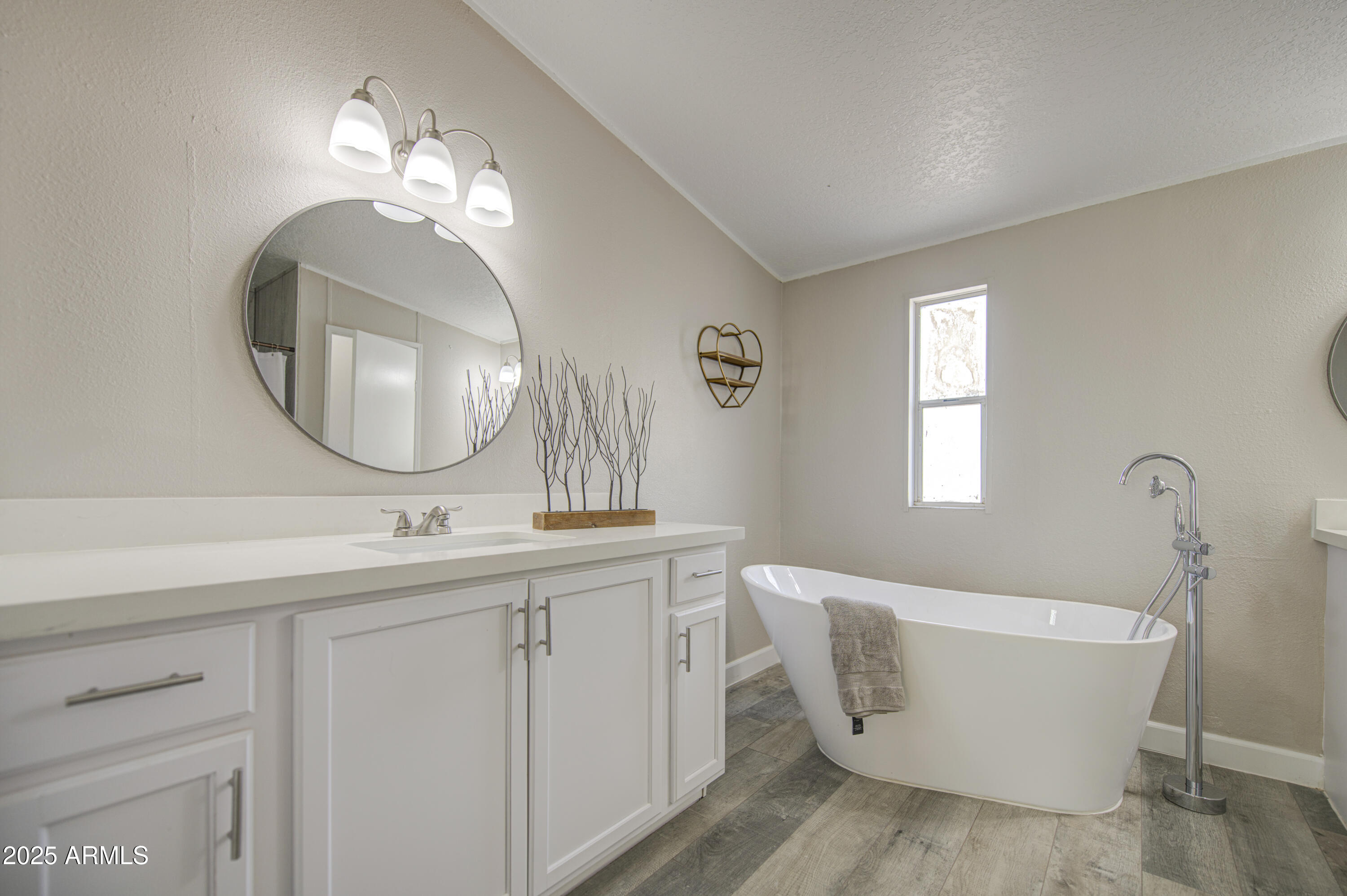 19954 West Teepee Road Buckeye, AZ 85326 - Photo 30 of 46 a bathroom with a bathtub a sink and a mirror