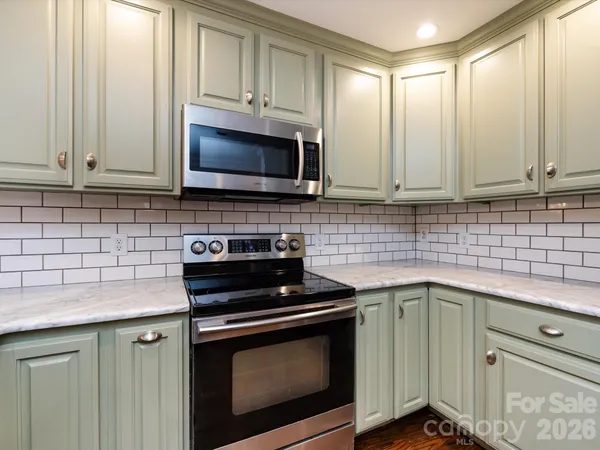 a kitchen with granite countertop cabinets stainless steel appliances and a sink