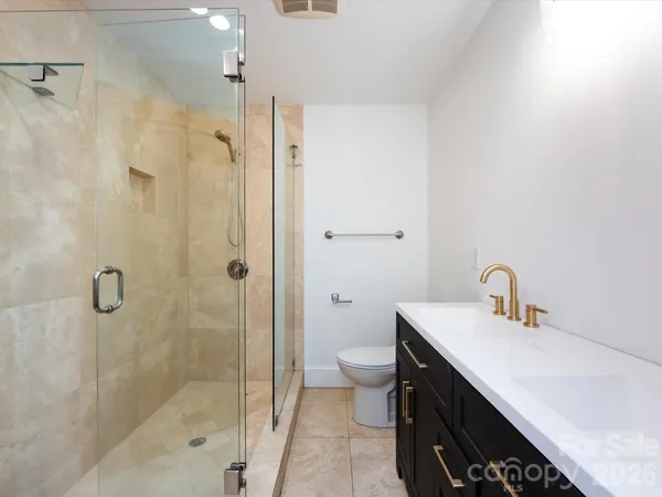 a bathroom with a sink a toilet and shower