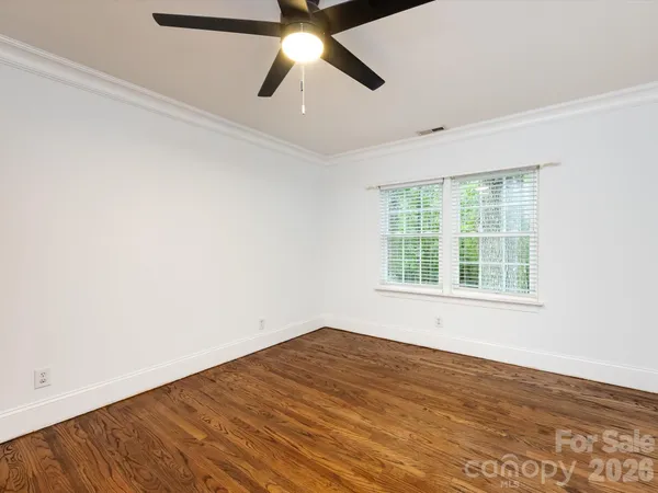 an empty room with a window and a ceiling fan