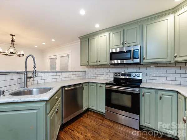 a kitchen with stainless steel appliances granite countertop a sink stove and microwave