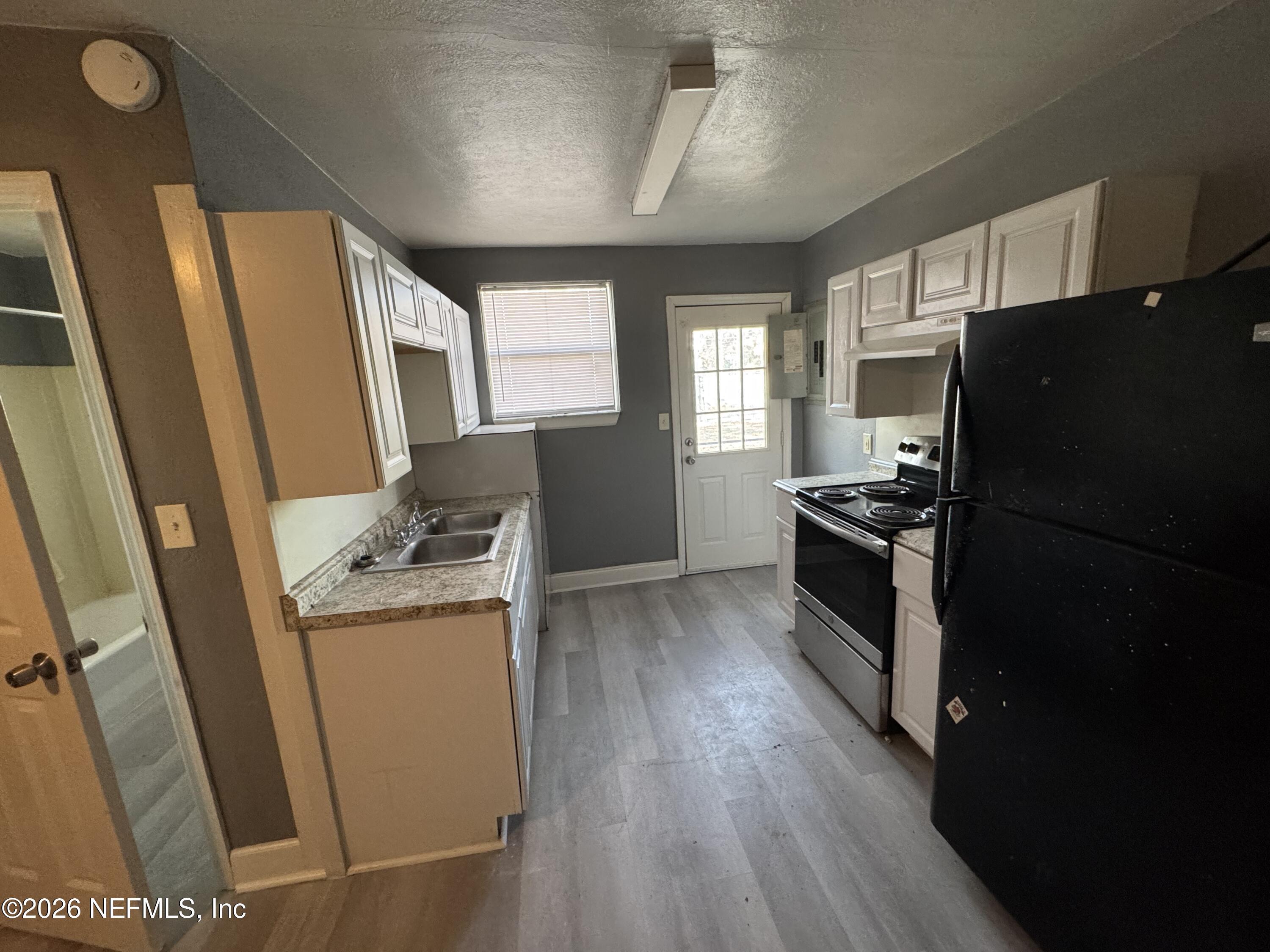 4114 Moncrief Road, Unit 2 Jacksonville, FL 32209 - Photo 5 of 20 a kitchen with a refrigerator a stove top oven a sink and dishwasher