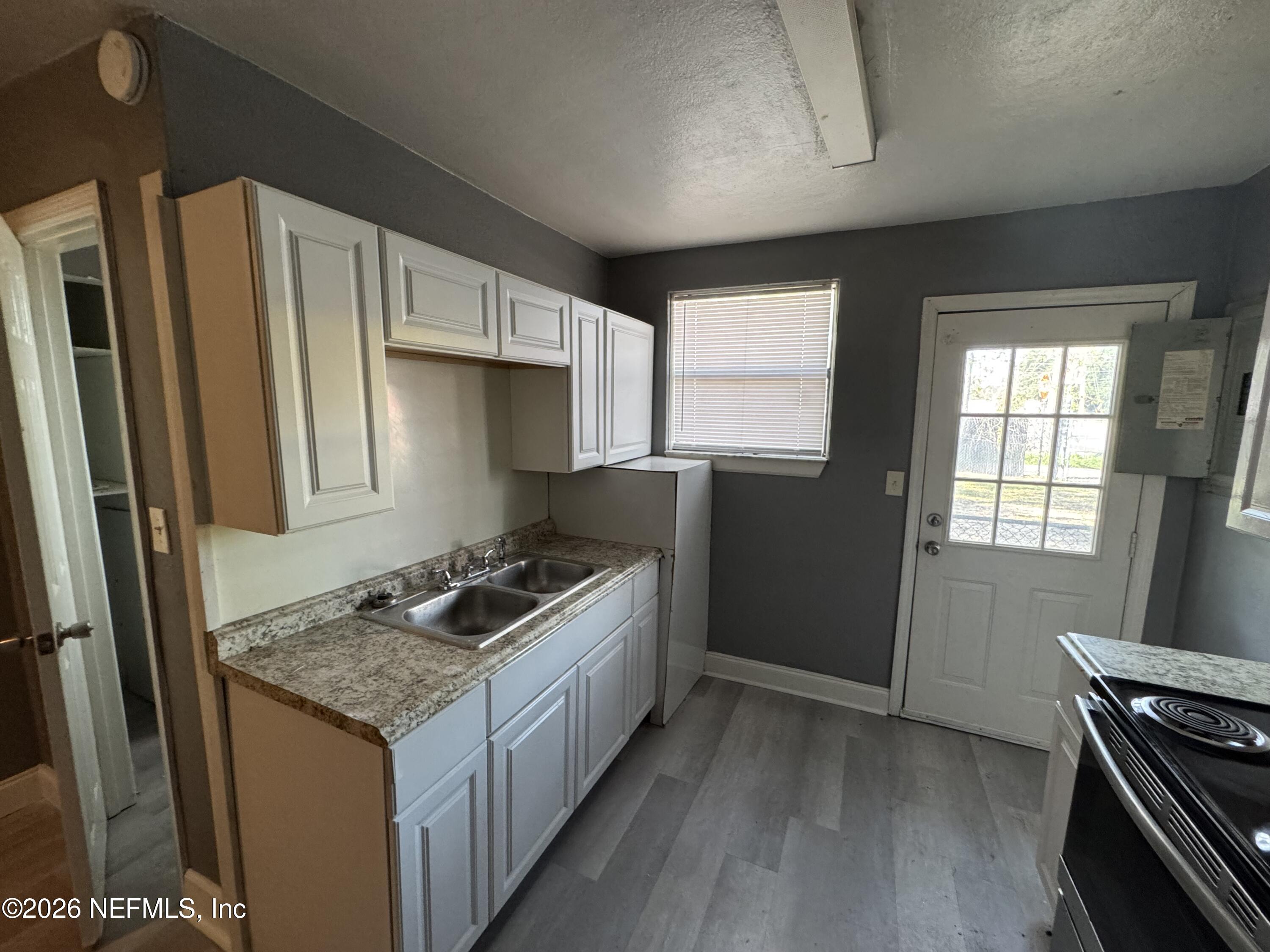 4114 Moncrief Road, Unit 2 Jacksonville, FL 32209 - Photo 6 of 20 a kitchen with granite countertop a sink stove and refrigerator