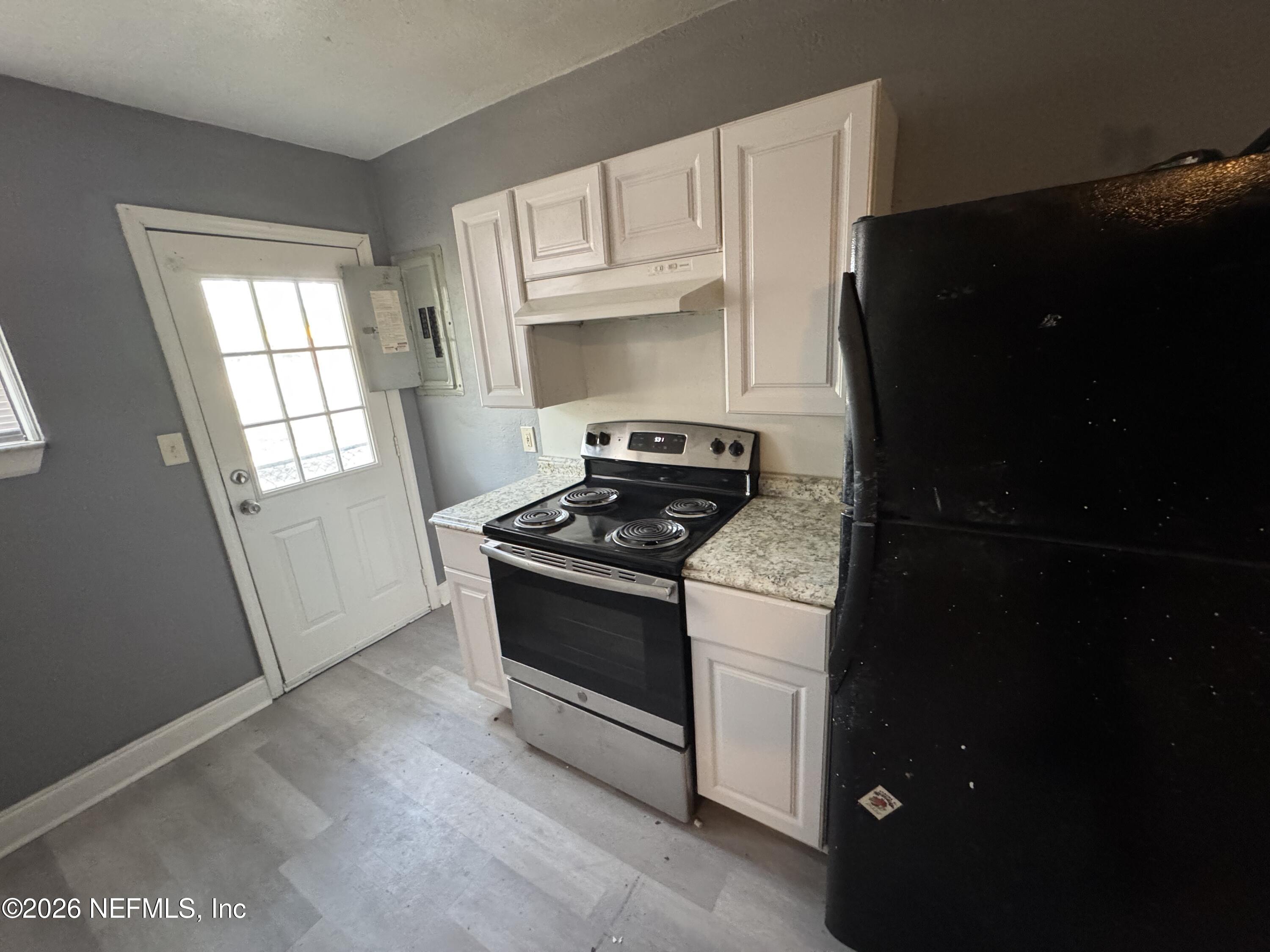 4114 Moncrief Road, Unit 2 Jacksonville, FL 32209 - Photo 7 of 20 a kitchen with granite countertop white cabinets and black appliances