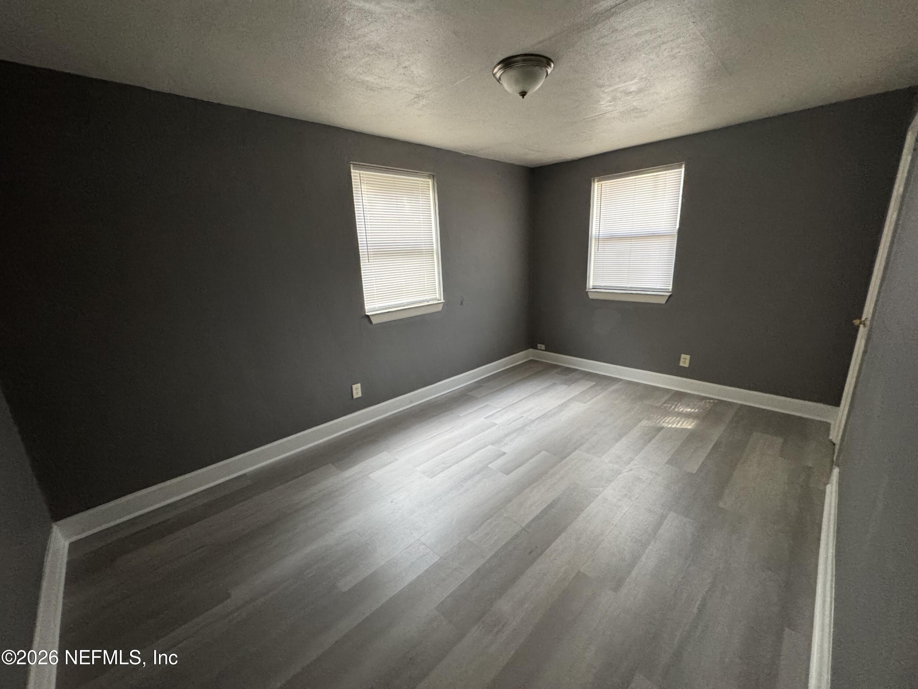 4114 Moncrief Road, Unit 2 Jacksonville, FL 32209 - Photo 8 of 20 an empty room with wooden floor and windows