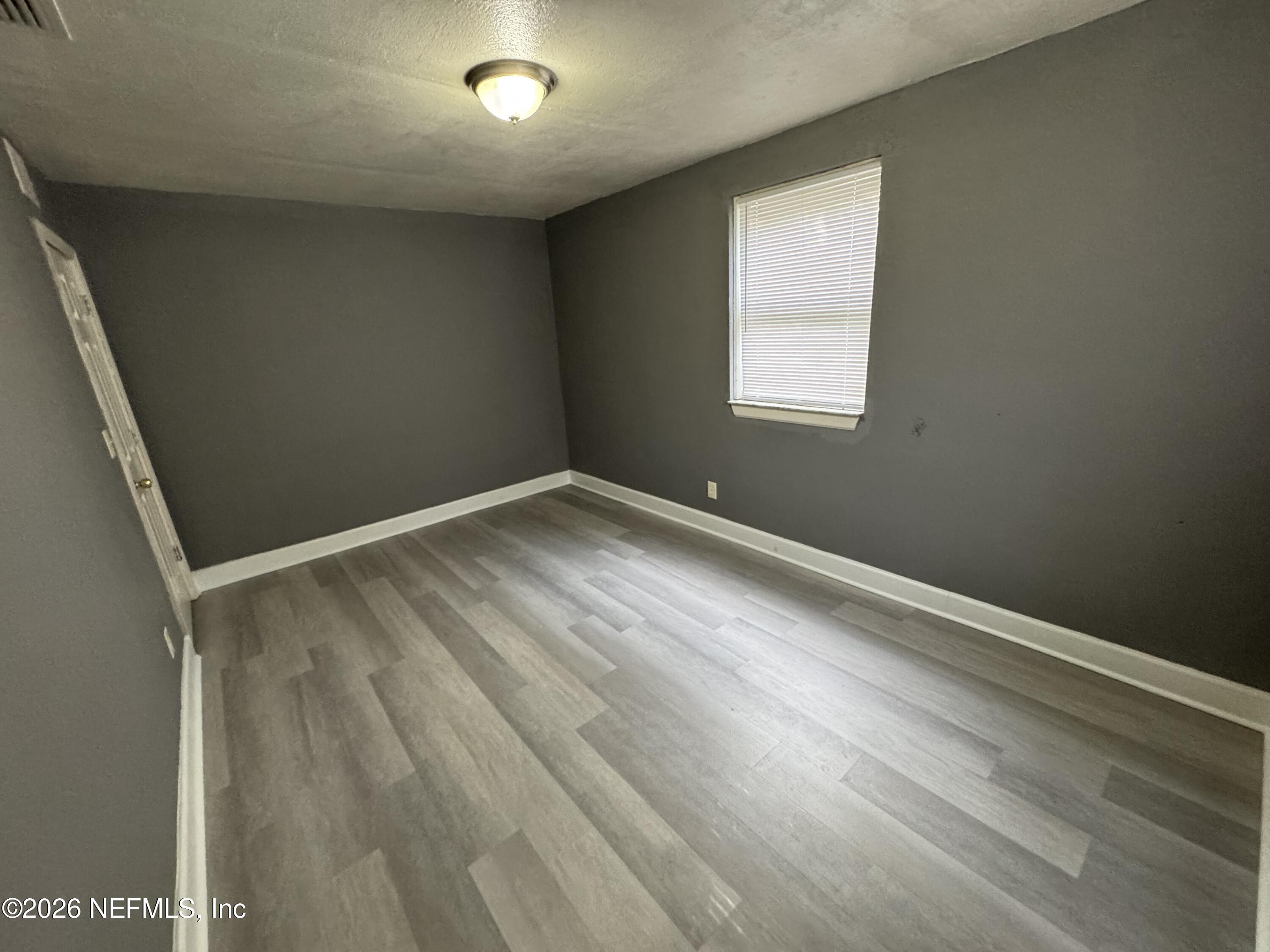 4114 Moncrief Road, Unit 2 Jacksonville, FL 32209 - Photo 10 of 20 an empty room with wooden floor and windows
