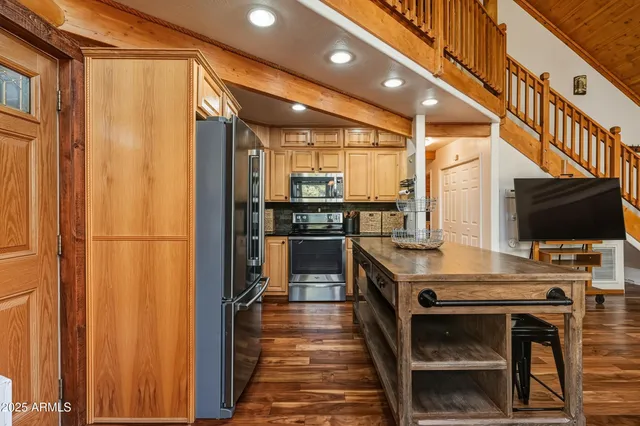 a kitchen with stainless steel appliances kitchen island granite countertop a table and chairs in it